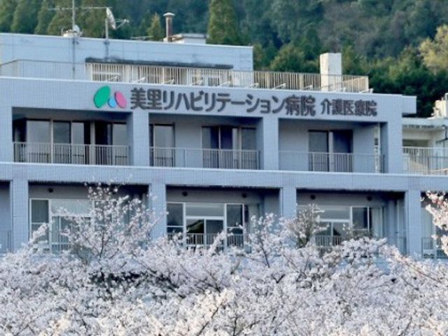 看板の外観 看板 施設の看板には、春の日差しを浴びた美しい桜が背景に広がっており、温かみを感じさせます。