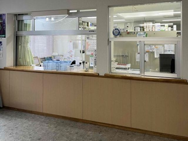 受付窓口のあるロビー フロント   木目調のカウンター越しに、受付の様子が見える落ち着いた窓口です。来訪対応のしやすさが伝わる配置になっています。