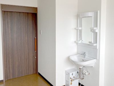 清潔な居室の入口と洗面台