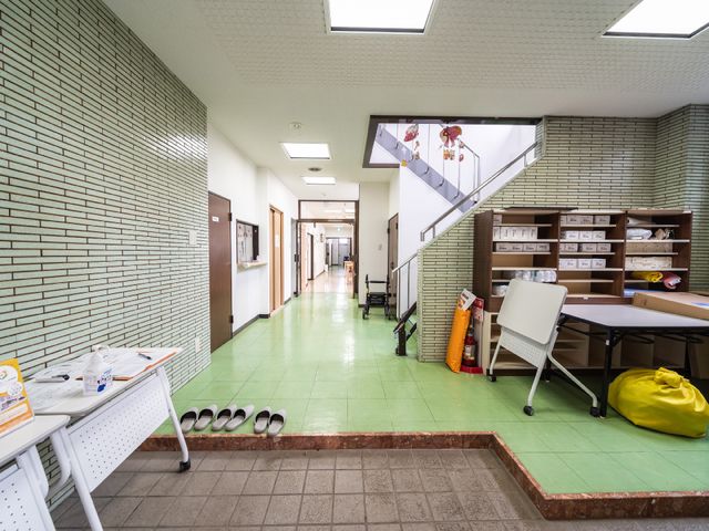 きれいな廊下と階段 玄関 丁寧に清掃された広々とした廊下が延びており、階段には手すりが設置されています。安心して歩ける環境で、日々の業務に集中できることでしょう。