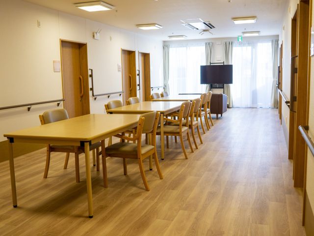 明るい食堂のテーブルと椅子 リビングダイニング 広々とした食堂には、木製のテーブルと椅子が整然と配置され、共に時間を過ごす空間が提供されています。