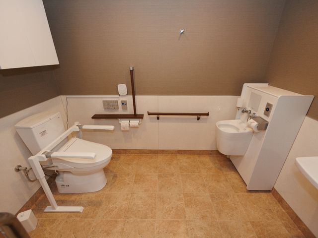バリアフリー対応のトイレ トイレ 安全で快適なサポート設備を備え、手すり付きのトイレスペースです。利用者の自立支援と尊厳を保つ設計になっています。