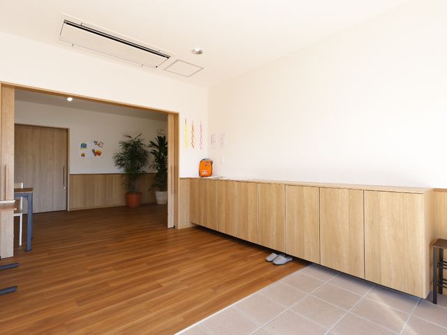 広々とした明るいロビー 玄関 木目調の家具が心地よい雰囲気を醸し出す、ゆとりあるロビーです。働きやすい環境が整っています。