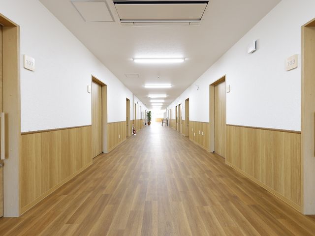 明るい木目調の廊下 廊下 広々として明るい廊下は、清潔感があり、皆さまの快適な生活をサポートします。壁には部屋番号が見やすく表示されております。