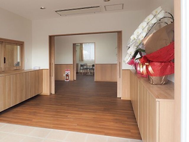木目調の床の廊下 玄関 ゆったりとした通路が特徴的な廊下で、車椅子の移動もしやすい設計になっています。清潔感あふれる空間で、気持ちよくお仕事ができそうです。
