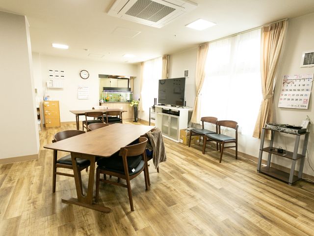 共用スペースの居心地の良さ 共用スペース ゆったりとしたダイニングルームは、コミュニケーションの場を提供し、温かい雰囲気で交流が楽しめます。木目調のフロアが落ち着いた印象を与えています。