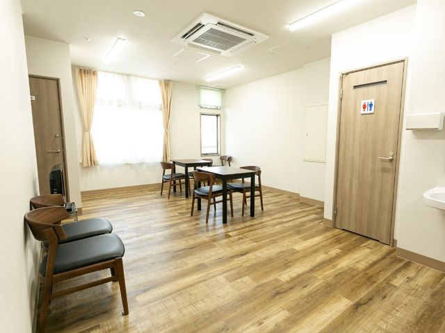 清潔な居室空間 共用スペース 広々とした居室は日差しもたっぷり入り、快適に過ごせる空間です。木目調のフロアが温かみのある雰囲気を演出しています。