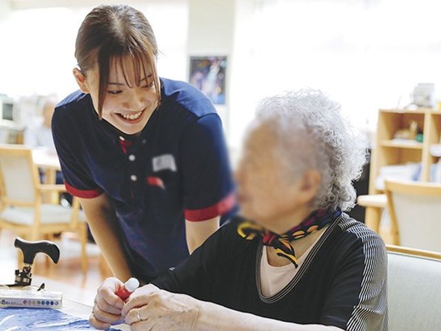 談笑するスタッフの笑顔 ラウンジ 広々とした明るい空間で、スタッフが利用者と和やかに談笑しています。リラックスした雰囲気が魅力です。