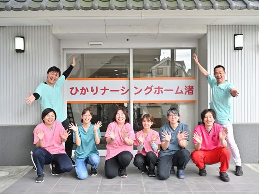 笑顔のスタッフが玄関前で集合するエントランス  