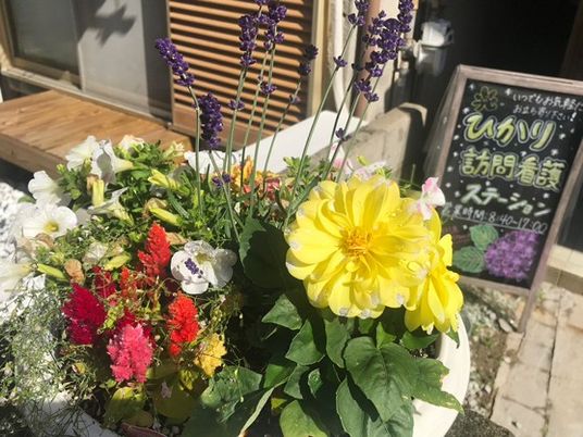 花の飾りと案内板のある外観  