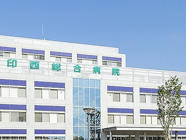 総合病院の外観 外観   白い外壁が印象的な建物で、中央の大きな窓が目を引きます。青空の下に見える、明るく開放感のある外観です。