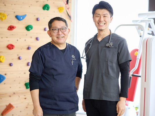 運動器具前の職員2人と訓練室  