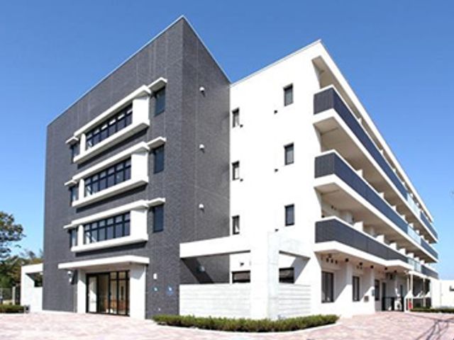 モダンな白と黒の建物 外観 洗練されたデザインの建物は、清潔感と安心感を与える環境です。様々なサービスを提供しています。