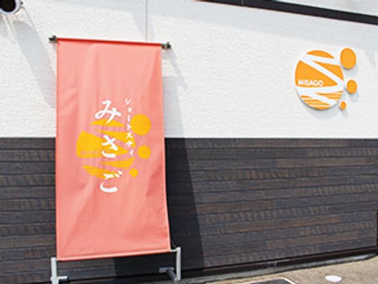 施設の看板前
