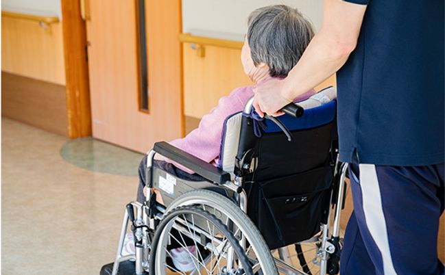 車椅子の人とスタッフの廊下  