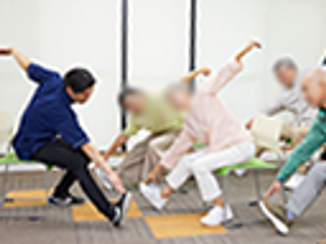 シニア向けの運動 機能訓練室 明るい室内で椅子を利用した運動をしており、リラックスして体を動かせる環境です。