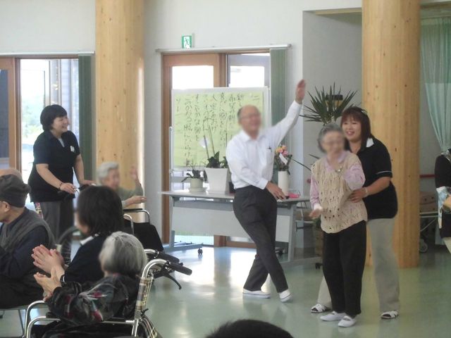 活動中の人々 ラウンジ 広々としたラウンジで、介護スタッフと入居者が和やかに活動しています。明るく過ごしやすい環境です。