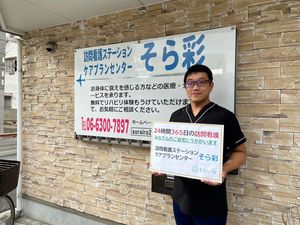 スタッフが案内板と一緒