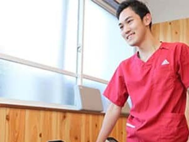 親切なスタッフの居室 居室 自然光が差し込む明るい空間で、スタッフが笑顔で介助を行っています。穏やかな環境です。