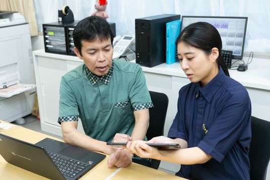 スタッフが端末を確認する場面  