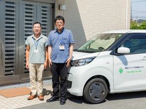 職員と送迎車の外観  