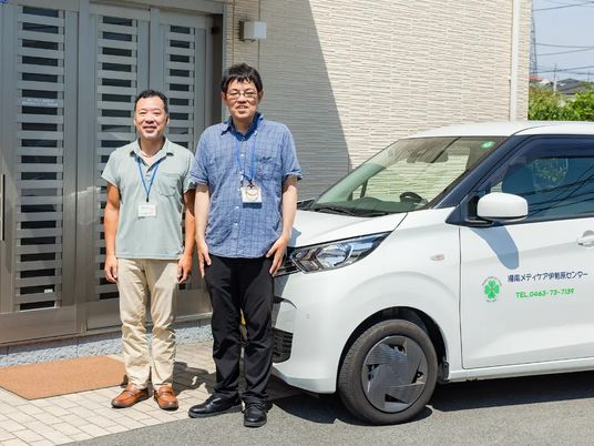 職員と送迎車の外観  