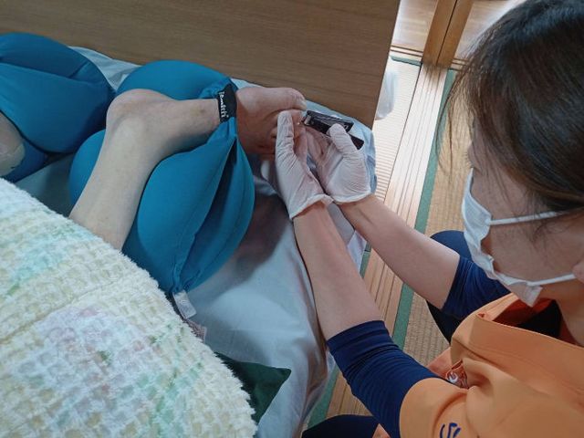 スタッフケアの様子 和室 介護スタッフが利用者の方に寄り添いながら、丁寧にケアを行っています。和やかな環境です。
