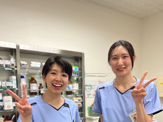笑顔のスタッフ2人と調剤棚  