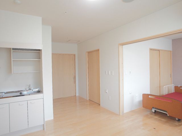快適な居室の一角 居室 この広々とした居室は、明るい日差しが差し込む安らぎの空間です。生活に必要な家具も整っており、落ち着いた生活を支援します。