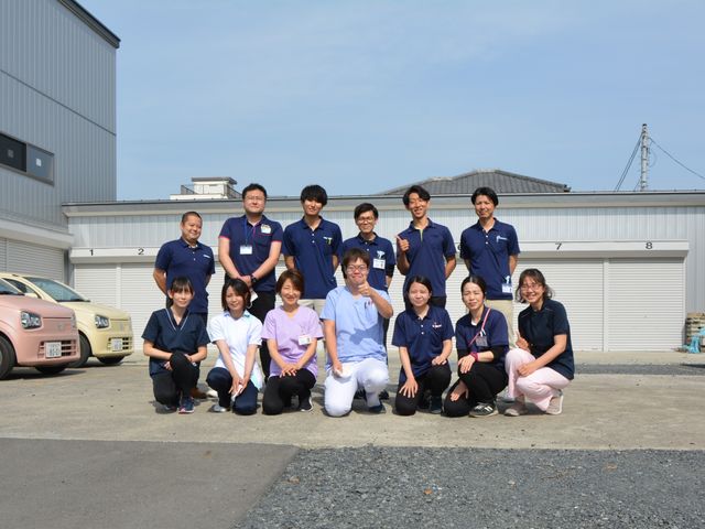 職員集合の外観前 外観   青空の下で職員の皆さんがそろっており、明るい雰囲気が伝わります。チームで働く様子をイメージしやすい場面です。