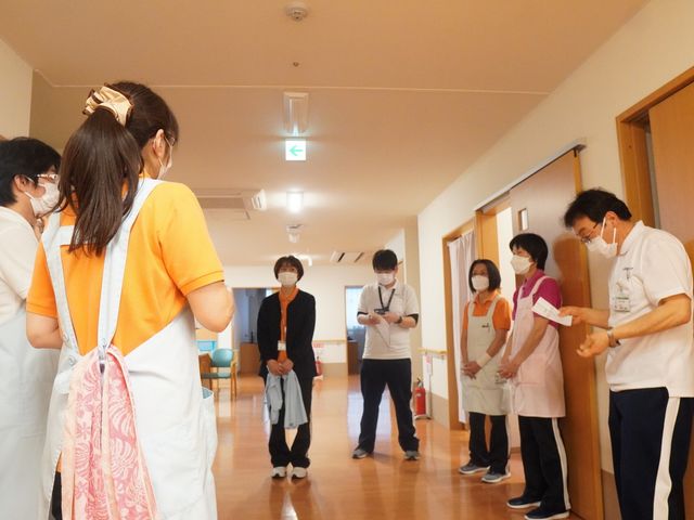 スタッフが集まる廊下 廊下 スタッフが集まり、意見を交換する場面です。協力し合ってより良いケアを目指しています。