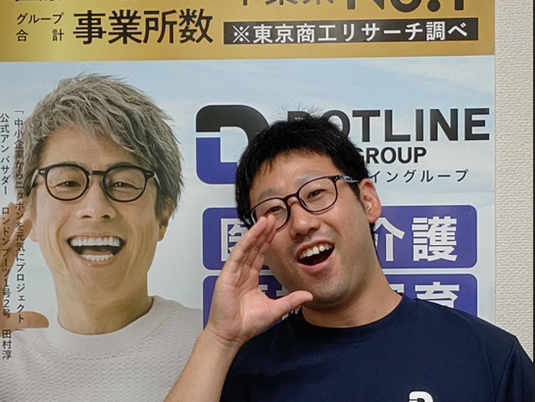 案内掲示の前で笑う男性  