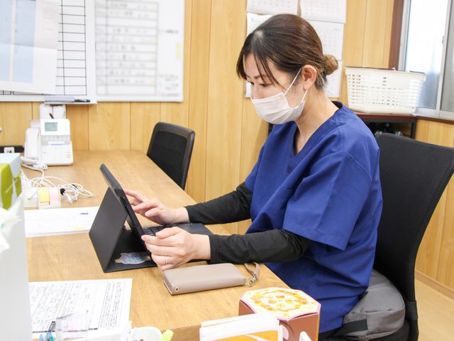スタッフイメージの女性 スタッフイメージ スタッフがデスクで書類を整理しています。安心して働ける環境が整っています。