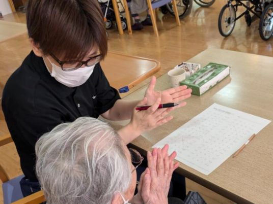 指導を受ける高齢者と介助者を描いた空間