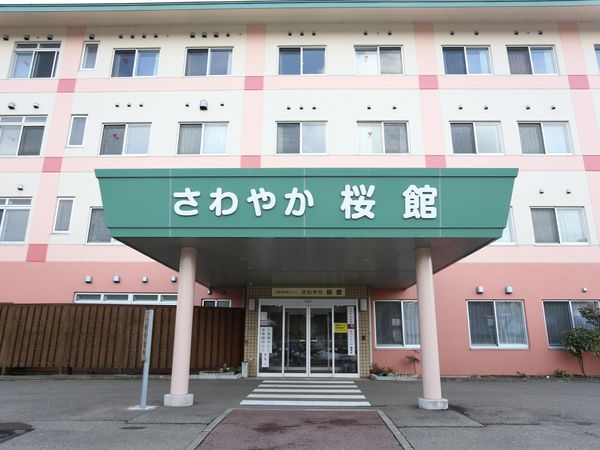 ピンクの外壁の建物エントランス