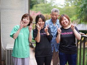 屋外で笑顔の職員と利用者  