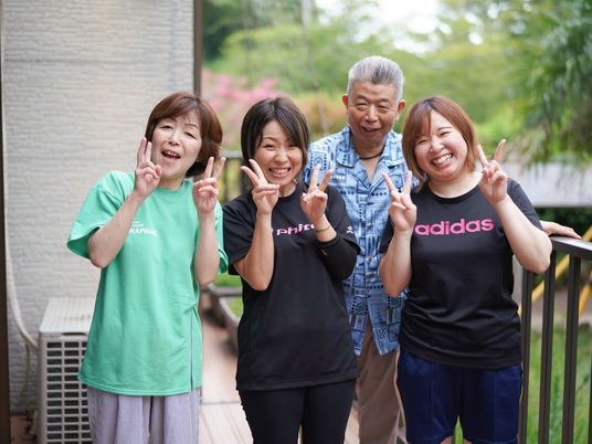 屋外で笑顔の職員と利用者  