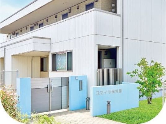 明るい外観と青い門の建物外観  