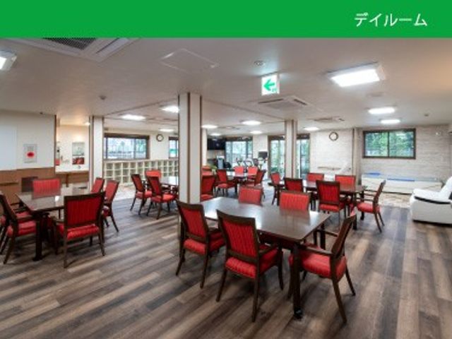 明るい食堂の室内 食堂   赤い椅子とテーブルがゆったり配置された、明るく開放感のある食堂です。窓から光が入り、休憩や食事の場として使いやすそうです。