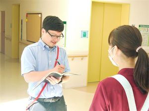 廊下で記録する職員  