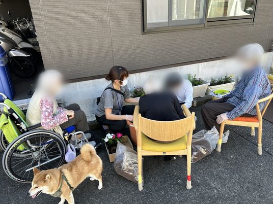 花植えを楽しむ人々と犬