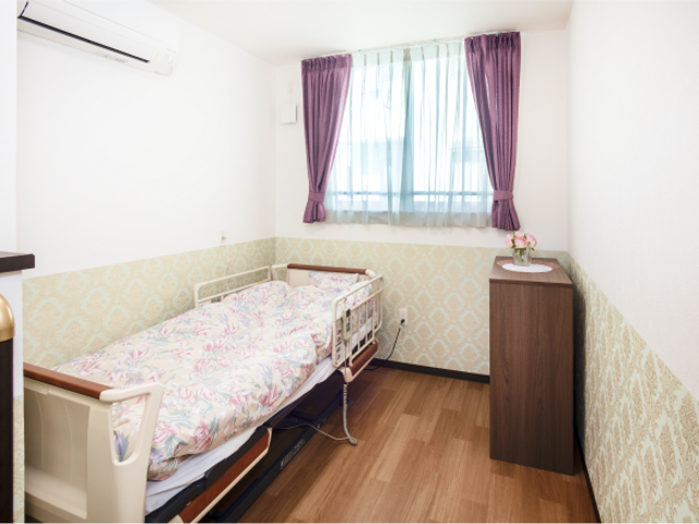 おしゃれな居室空間 居室 落ち着いた色合いの家具とカーテンが、穏やかな生活空間を演出しています。快適にお過ごしいただける居室です。