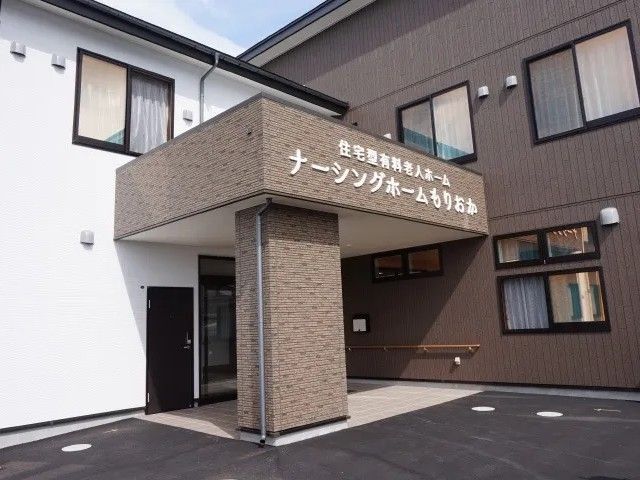 施設外観の正面玄関 外観   落ち着いた色合いの建物で、正面玄関まわりが見やすく整っています。来訪者や就業時の出入りをイメージしやすい外観です。