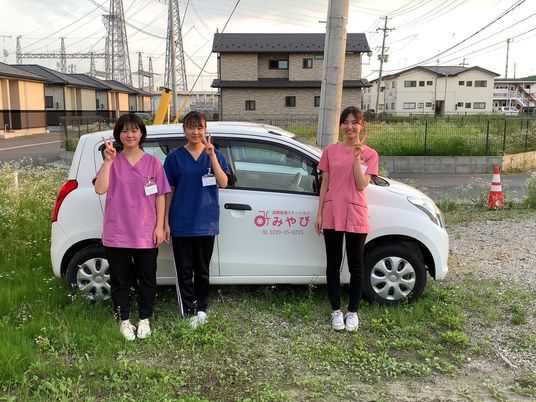 訪問看護の職員と送迎車  