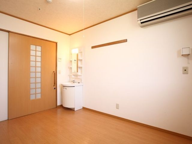 洗練された洋室の内観 居室 木目調の床が温もりを感じさせる洋室です。白を基調にした壁とシンプルな造りが、ゆとりのある生活空間を提供します。