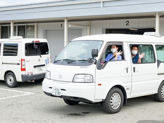 送迎車と職員の外観  