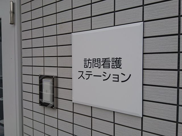 整備されたエントランス看板 エントランス 清潔で明るい入り口周りは、質の高い職場環境を予感させます。
