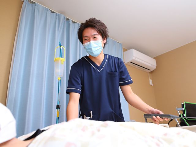 ケアスタッフと居室 居室 ケアスタッフが明るく対応する居室です。エアコン完備で快適に過ごせます。