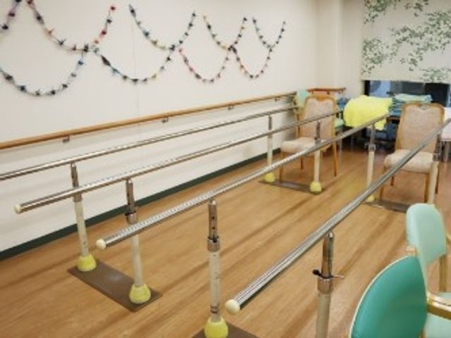 手すり付き機能訓練室 機能訓練室   手すりが並ぶ広めの訓練スペースです。歩行練習や立ち座りの練習に使いやすそうです。