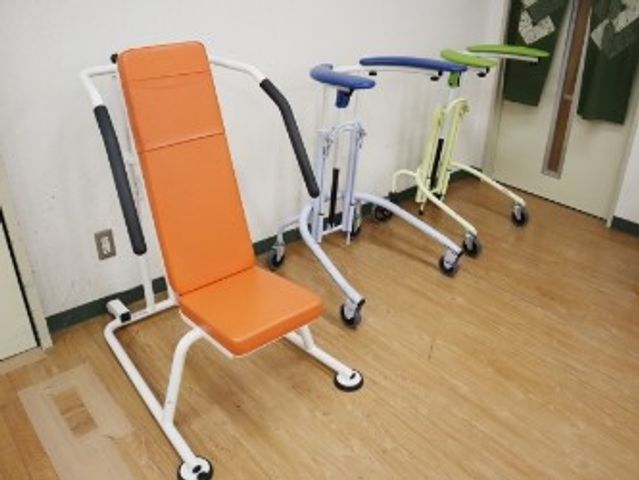 リハビリ機器のある部屋 機能訓練室   広い床面に運動器具が並び、落ち着いて体を動かしやすい空間です。明るい室内で、就業時の動線も確認しやすそうです。